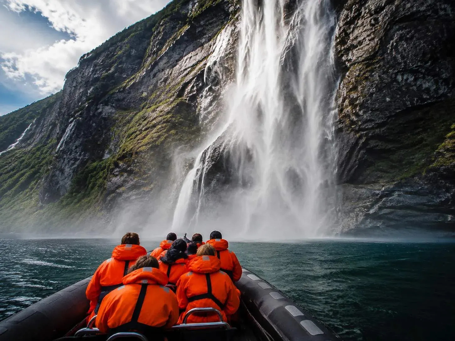 Ein RIB-Safari-Boot nahe den Wasserfällen auf dem Geirangerfjord